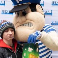 Louie the Laker shares popcorn with boy